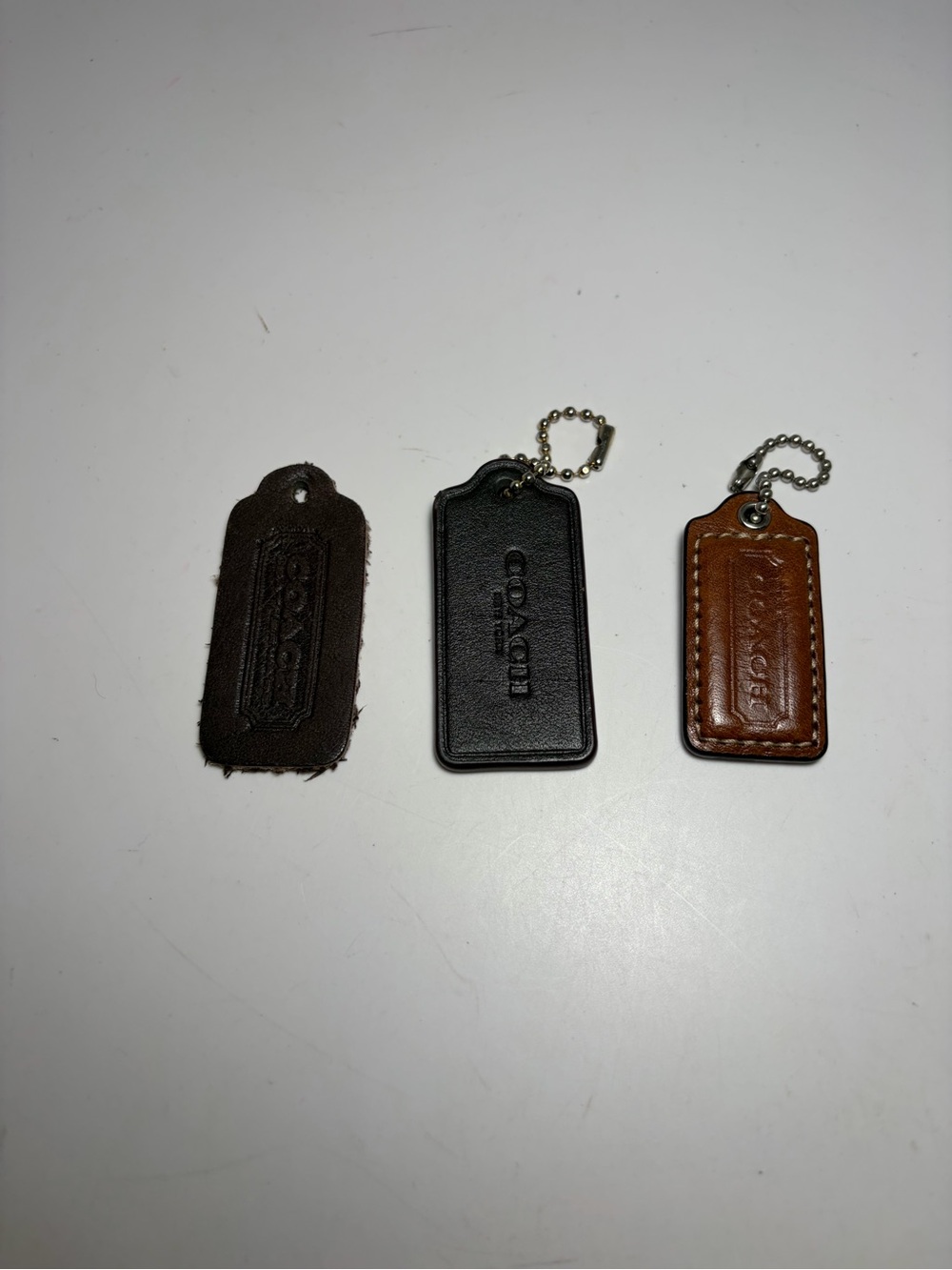 Coach Leather Key & Card Tag Trio in Black, Dark Brown, and Tan